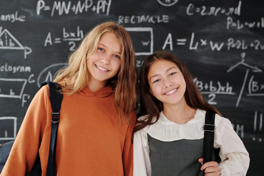 two school girls smiling after visiting Kirkland, WA dentist for kids